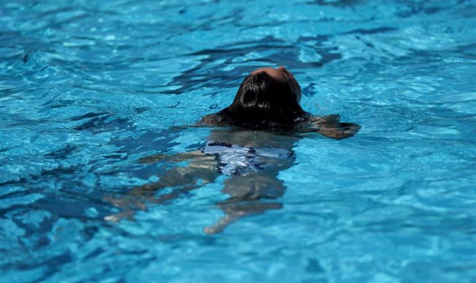 Archivo - Una bañista nada en la piscina municipal de Casa de Campo