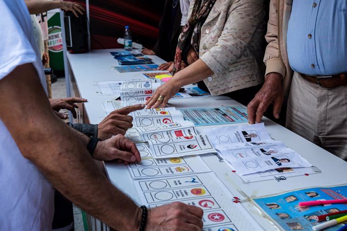 Un grup de persones examina unes paperetes abans de les presidencials i parlamentries del 14 de maig a Turquia