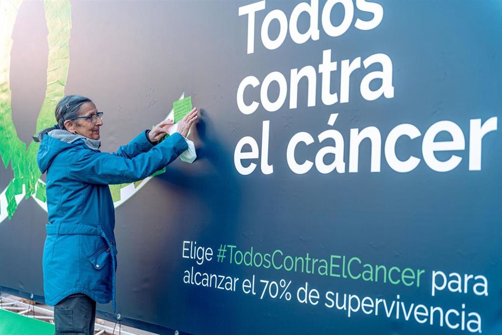Archivo - Una mujer pega una nota con un mensaje de apoyo en la formación de un lazo verde durante un encuentro con motivo del Día Mundial contra el Cáncer en la Plaza Margaret Thatcher, a 4 de febrero de 2023, en Madrid (España).
