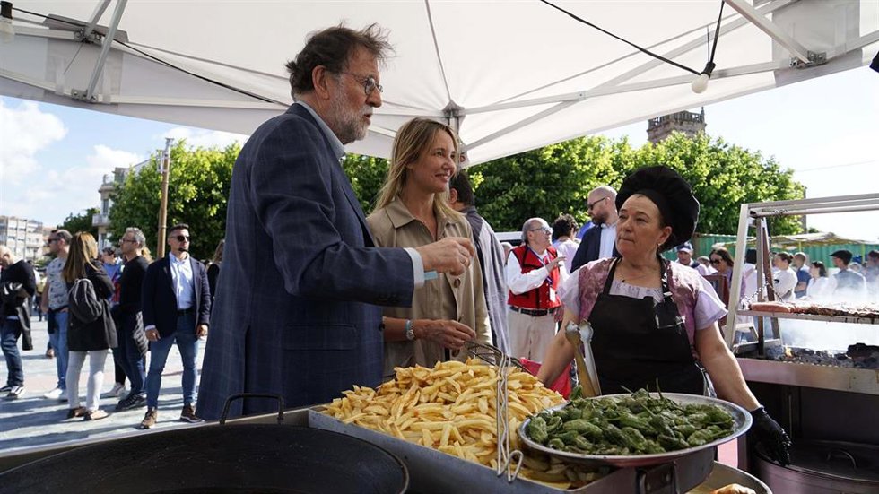 El presidente de honor del Partido Popular de Galicia (PPdeG) y expresidente del Gobierno de España, Mariano Rajoy (i), y la candidata del PP a la Alcaldía de Vigo, Marta Fernández-Tapias (c), durante su visita al barrio de Bouzas en la Brincadeira 2023.