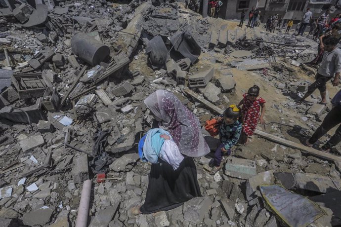 May 13, 2023, Gaza City, The Gaza Strip, Palestine: People gather around the rubble of a building destroyed in an Israeli air strike in Beit Lahia in the northern Gaza Strip, on May 13, 2023. Israeli air strikes battered Gaza again on May 13 in response
