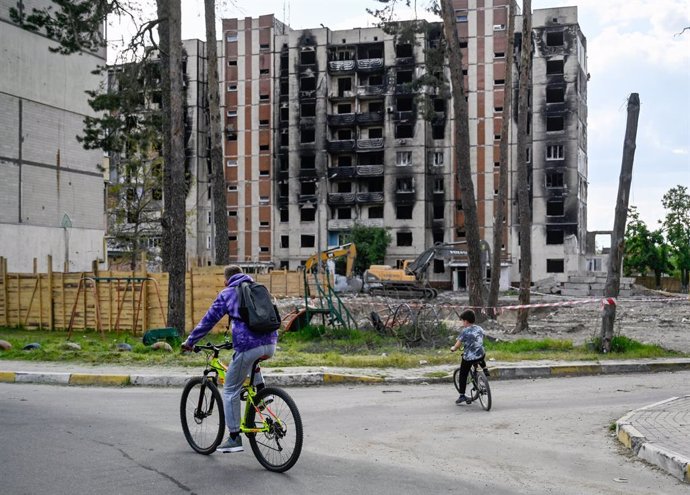 May 13, 2023, Irpin, Ukraine: People ride bikes near a badly damaged apartment building that was damaged by the Russian army's invasion of Ukraine. Russia invaded Ukraine on 24 February 2022, triggering the largest military attack in Europe since World 
