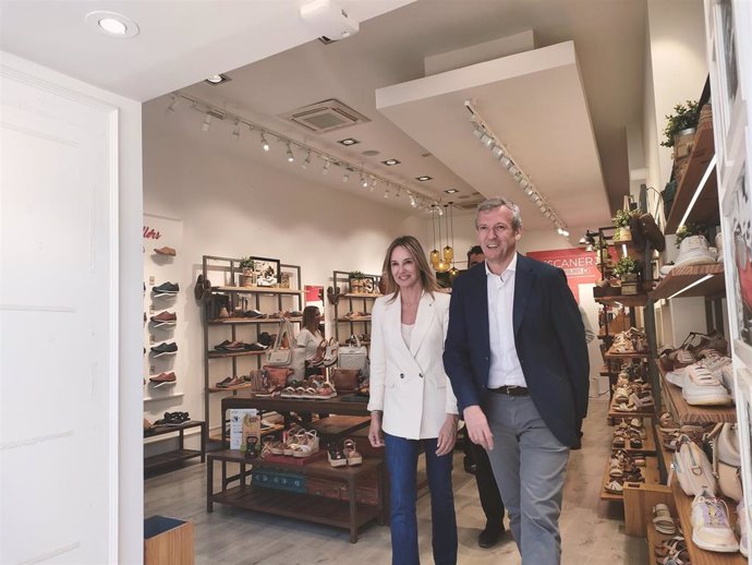 La candidata del PP a la Alcaldía de Vigo, Marta Fernández-Tapias, saliendo de una zapatería con el presidente del PPdeG, Alfonso Rueda, en un paseo de campaña electoral por la ciudad olívica.