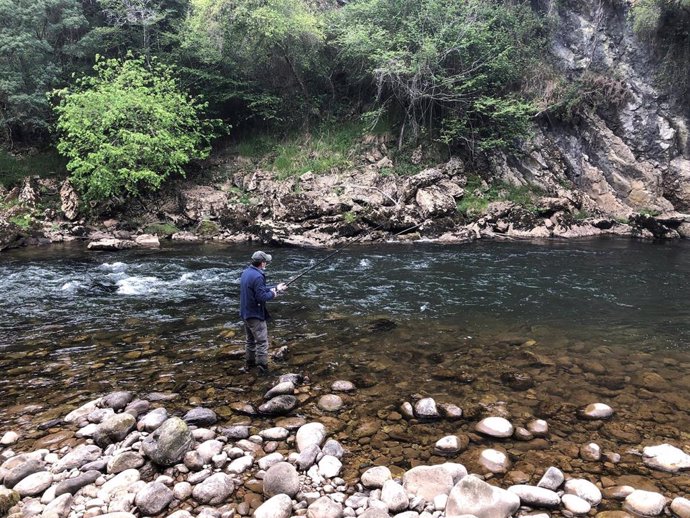 Archivo - Pescador en un río