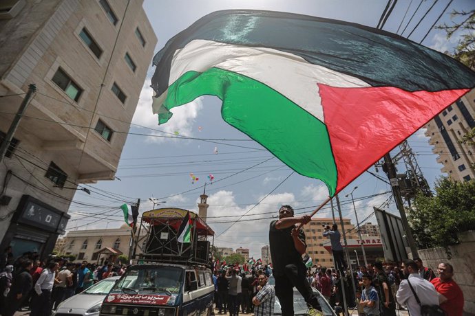 Archivo - 15 May 2022, Palestinian Territories, Gaza City: A man waves the Palestinian national flag during during a rally marking the 74th anniversary of Nakba Day (Memory of the Catastrophe), an annual day commemorating the displacement of Palestinian