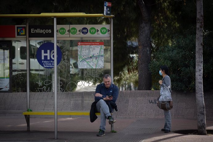 Archivo - Arxiu - Dues persones esperen l'autobús, durant la vaga d'autobusos, a 17 de febrer de 2022, a Barcelona.