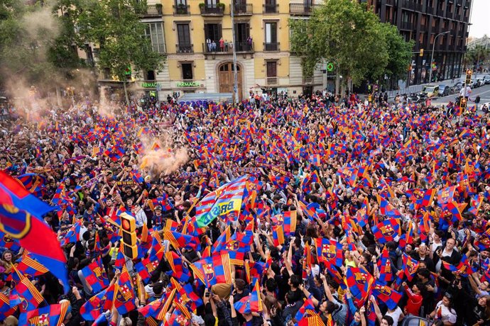 Aficionados celebrando la Liga del FC Barcelona en la rúa de celebración.