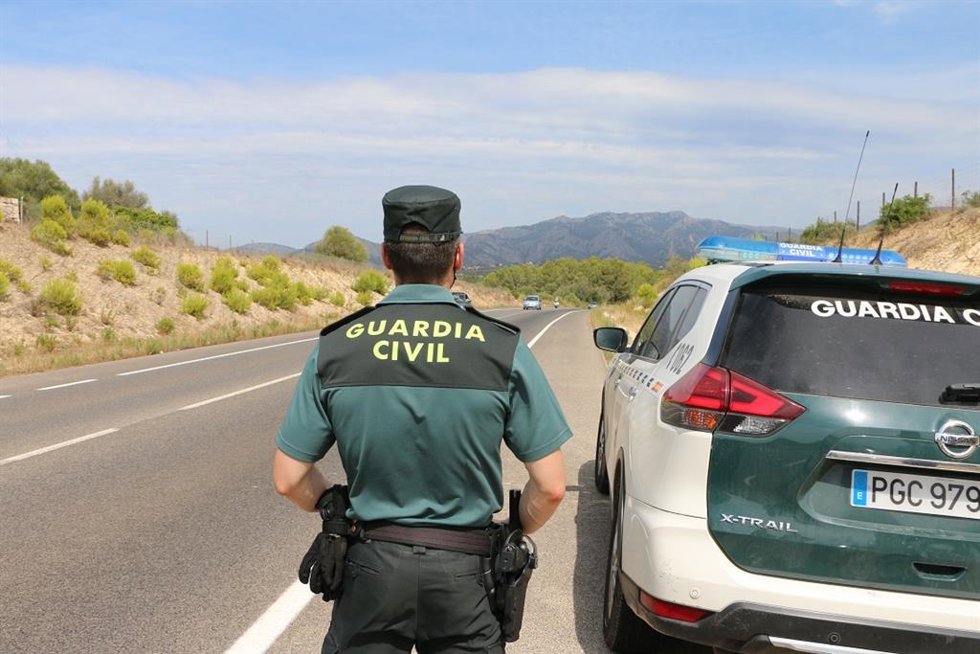 Un agente de la Guardia Civil, junto a un vehículo del cuerpo.