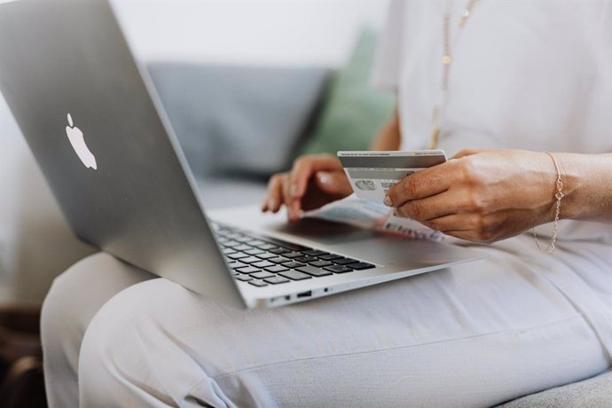 Mujer con ordenador haciendo compra online.