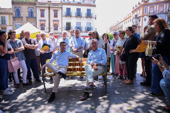 El presidente del PP-A y de la Junta de Andalucía, Juanma Moreno, (i) y el candidato del PP a la Alcaldía de Sevilla, José Luis Sanz, (d) en su visita al barrio de Triana.