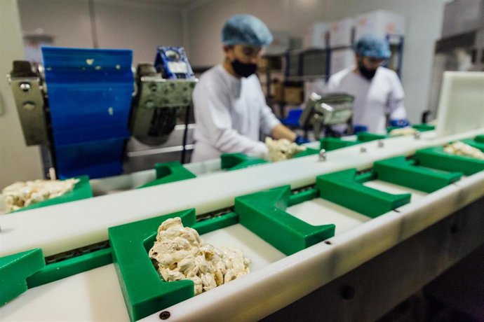 Archivo - Varios trabajadores en una fábrica