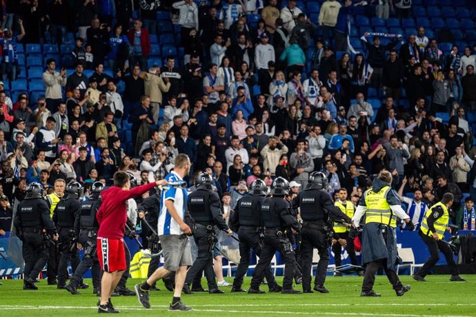 Los Mossos de Esquadra saltan al terreno de juego del RCDE Stadium tras la invasión de campo por parte de aficionados del Espanyol durante la celebración del FC Barcelona por la conquista del título liguero