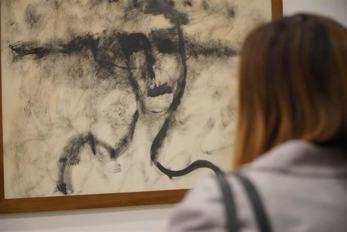 Una persona observa una de las obras de la muestra 'Joan Trujillo: donar llum a la foscor'.