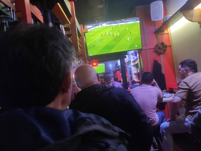 Personas viendo un partido en un bar