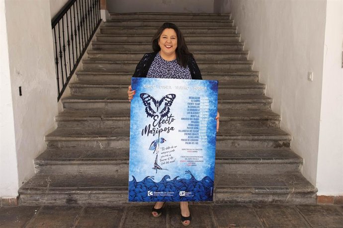 La delagada de Cohesión Social, Consumo y Participación Ciudadana de la Diputación de Córdoba, Dolores Amo, posa con el cartel de 'Efecto mariposa'.