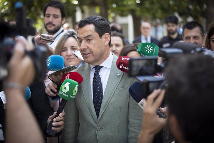 El presidente de la Junta de Andalucía, Juanma Moreno (2d) atiende a los medios de comunicación a su llegada a la sesión plenaria. (Foto de archivo).