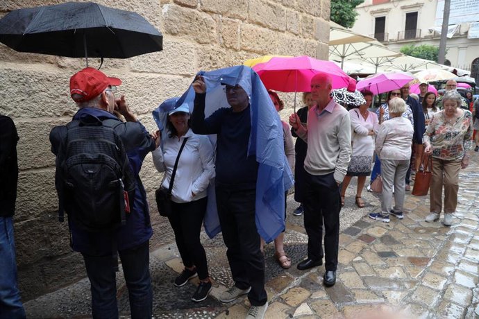 Cientos de turistas se resguardan de la lluvia, archivo 