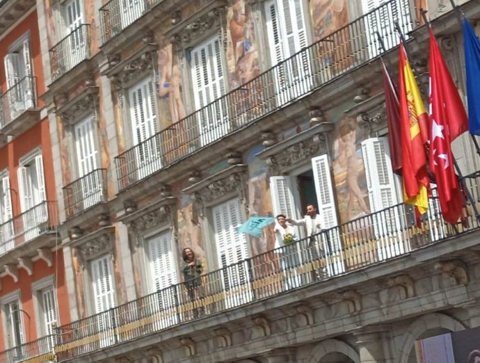 28M.- Recién Casados Salen Al Balcón De La Plaza Mayor, Donde Más Madrid Celebra Su Mitin, Con Una Bandera Del Partido