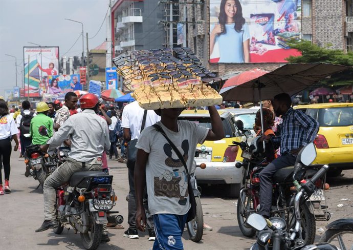 KINSHASA, May 14, 2023  -- A vendor walks in the street of Kinshasa, the Democratic Republic of the Congo (DRC), on May 11, 2023. Kinshasa is the capital, the largest river port and the largest city of the Democratic Republic of Congo and is also the po