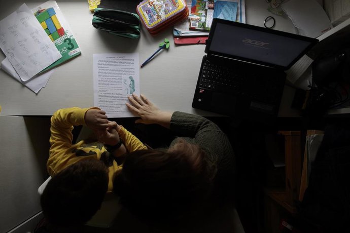 Archivo - Un niño estudia y hace los deberes en casa con la ayuda de su madre, foto de recurso