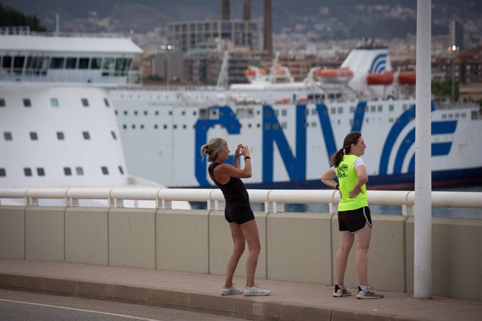 Archivo - Dos chicas hacen una fotografía frente a la terminal de cruceros del Puerto de Barcelona, visto desde el Puente de la Puerta de Europa, a 30 de mayo de 2022, en Barcelona, Cataluña (España). 