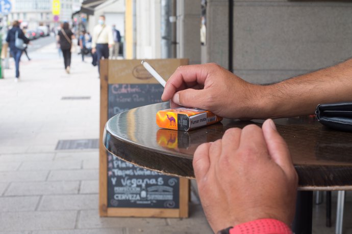 Archivo - Una persona fuma en una terraza, en Lugo, Galicia, (España), a 13 de agosto de 2020.