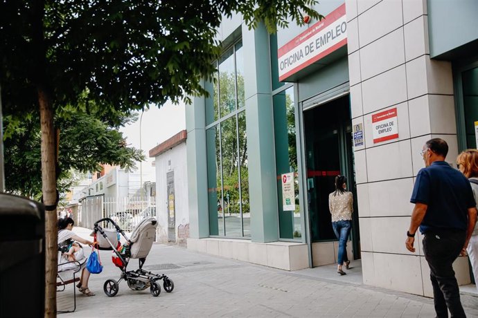 Archivo - Una mujer entrando en una oficina de empleo