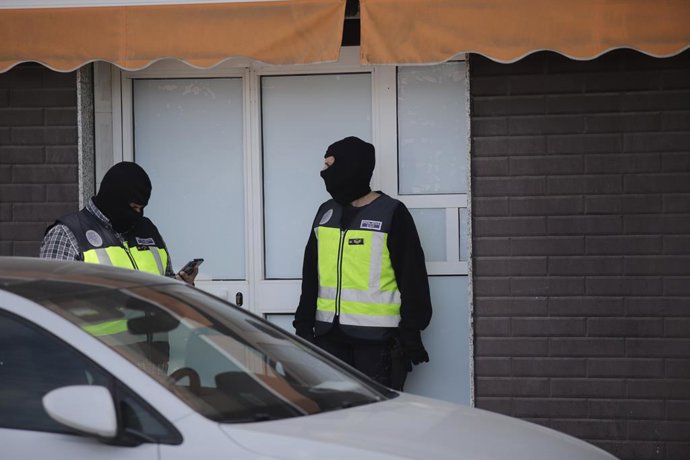 Dos agentes de la Policía Nacional en la puerta de un domicilio en Melilla en la operación por presunto fraude electoral con la compra de votos