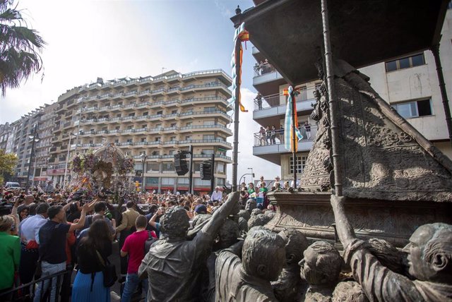 Huelva despide a la Hermandad de Emigrantes a su paso por el monumento a la Virgen del Rocío antes de partir hacia la aldea almonteña.