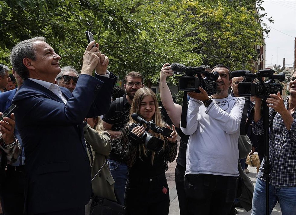 El expresidente del Gobierno José Luis Rodríguez Zapatero, toma una fotografía durante un encuentro con los vecinos del poblado marítimo del Cabañal