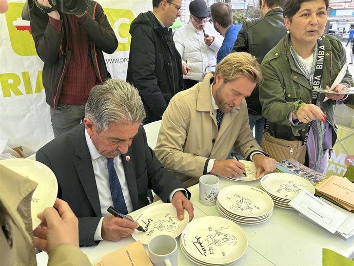 Revilla y Piña firman platos y tazas en la carpa del PRC en el Ayuntamiento.