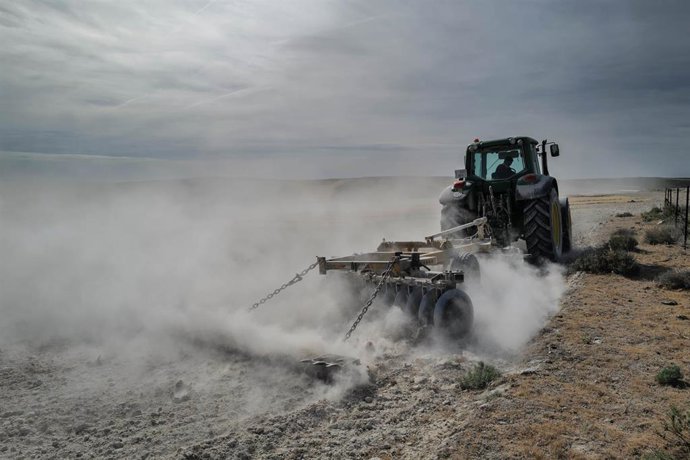Un tractor para arar la tierra en el campo de Belchite