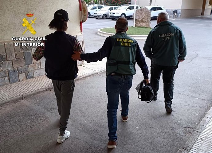 Agentes de la Guardia Civil custodian a uno de los detenidos