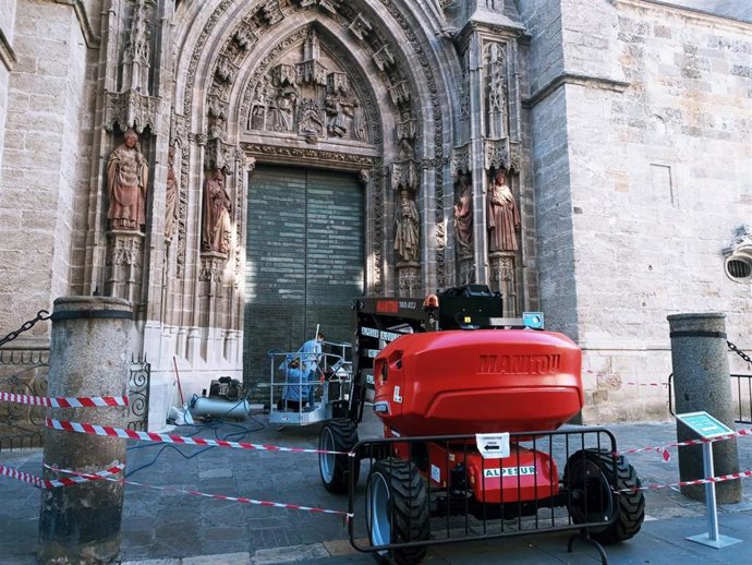 Operarios realizan labores de mantenimiento en la Puerta de San Miguel de la Catedral.