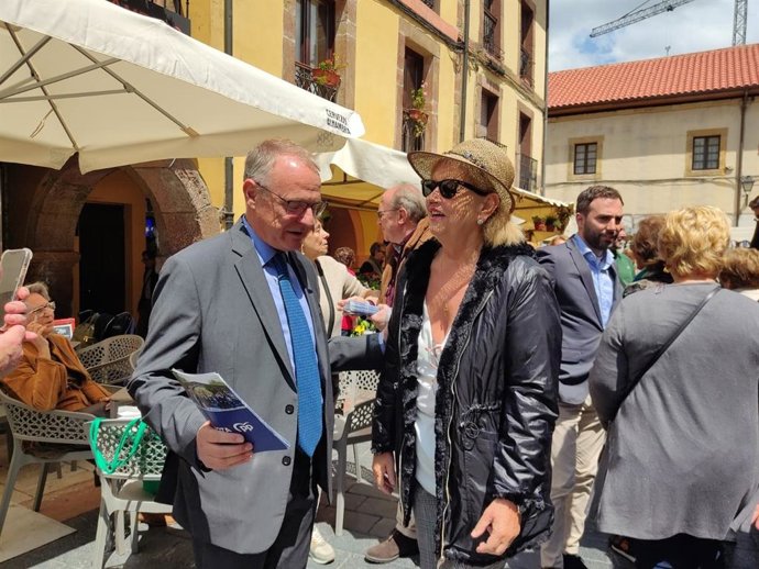 El candidato del PP, Diego Canga, charla con vecinos en su visita al mercado del Fontán, en Oviedo.