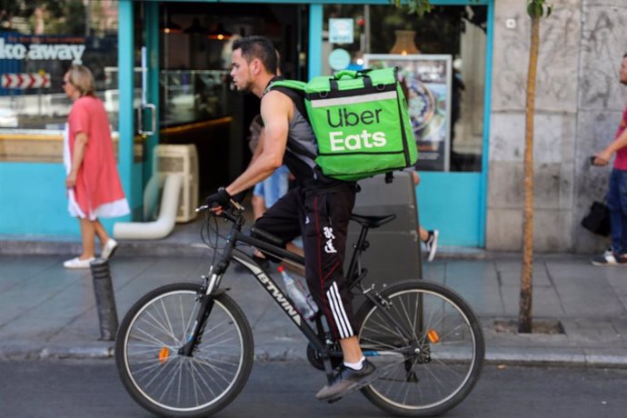 Archivo - Fotografía de un repartidor de la empresa de reparto Uber Eats transitando en bicicleta por una calle del centro de Madrid.