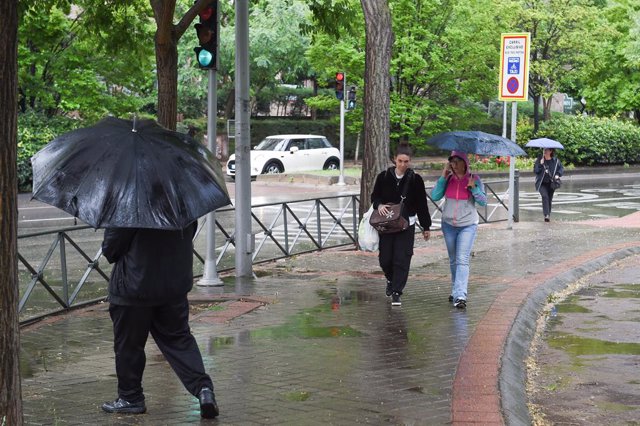 Varias personas pasean bajo la lluvia, a 23 de mayo de 2023, en Madrid (España). La Agencia Estatal de Meteorología (Aemet) prevé lluvias en la región madrileña todo lo que queda de semana ocasionadas por una DANA (Depresión Aislada en Niveles Altos) que 