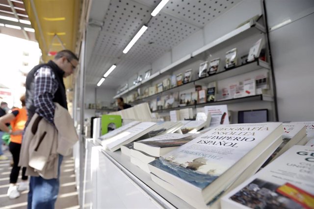 Archivo - Varias personas pasean y realizan compras en la Feria del Libro. 