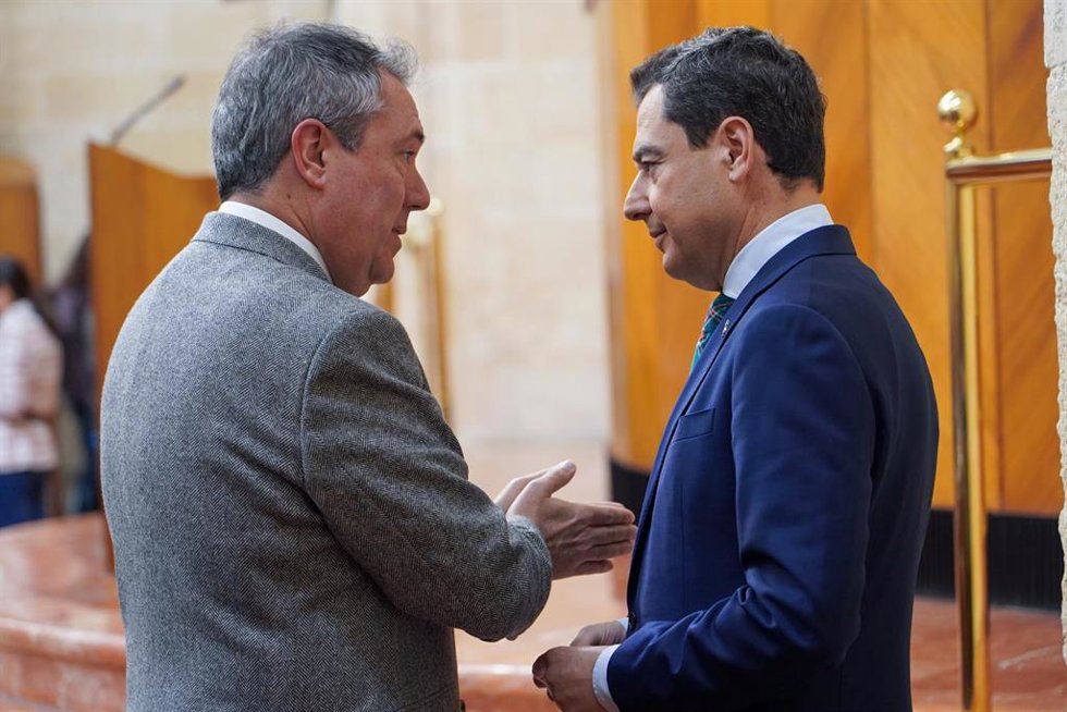 Archivo - El presidente de la Junta de Andalucía, Juanma Moreno, (d) dialoga con el secretario general del PSOE de Andalucía y presidente del Grupo Parlamentario Socialista, Juan Espadas, (i) en una foto de archivo en el Parlamento andaluz.