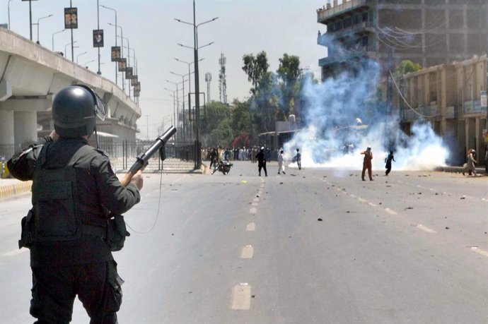 10 May 2023, Pakistan, Peshawar: A Pakistani security officer fires tear gas at a protest by supporters of Pakistan Tehreek-e-Insaf party (PTI), following the arrest of former prime minister Imran Khan from the premises of Islamabad High Court. Photo: Ppi