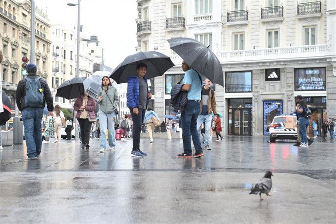 Varias personas pasean bajo la lluvia, a 23 de mayo de 2023, en Madrid (España). La Agencia Estatal de Meteorología (Aemet) prevé lluvias en la región madrileña todo lo que queda de semana ocasionadas por una DANA (Depresión Aislada en Niveles Altos) qu