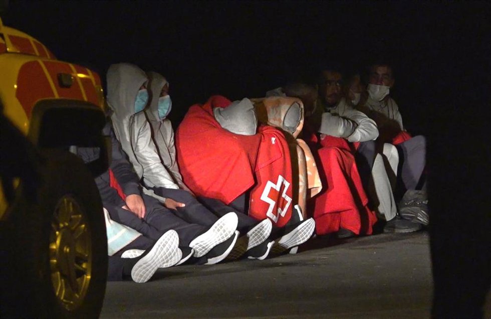 Archivo - Tapadas con mantas de Cruz Roja. algunas de las 27 personas que lograron llegar a tierra con vida tras el vuelco de la patera en la que viajaban en la noche de este martes,  en la costa de Órzola, en la zona de La Condesa, en Lanzarote, Canari
