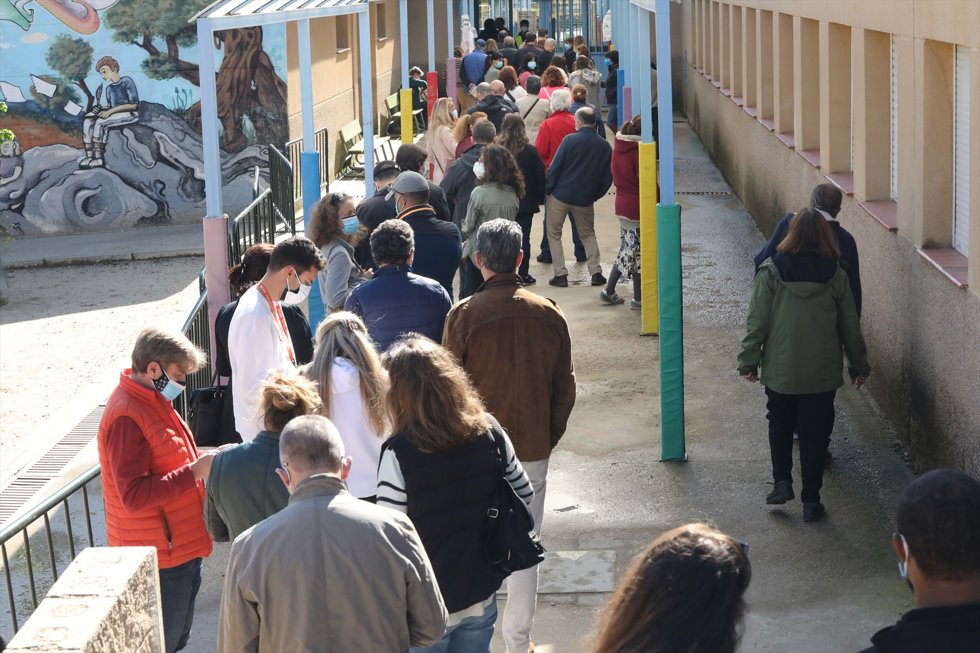 Decenas de personas hacen cola para votar en el Colegio Público La Navata, a 4 de mayo de 2021, en Madrid (España).