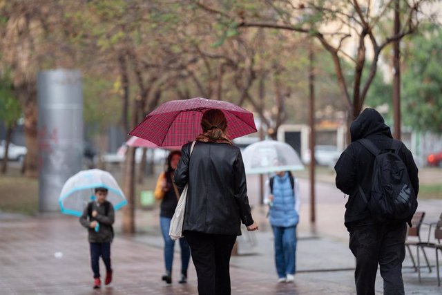 Varias personas con paraguas pasean por una de las calles de la ciudad, a 12 de mayo de 2023, en Barcelona, Catalunya (España). 