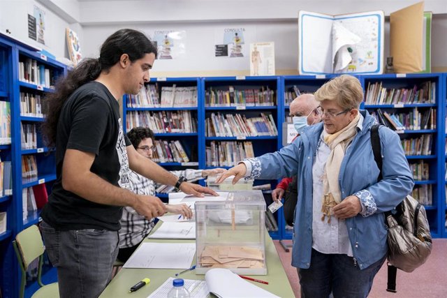 Una mujer mete su voto en una urna en un colegio electoral, a 28 de mayo de 2023, en Madrid (España).  