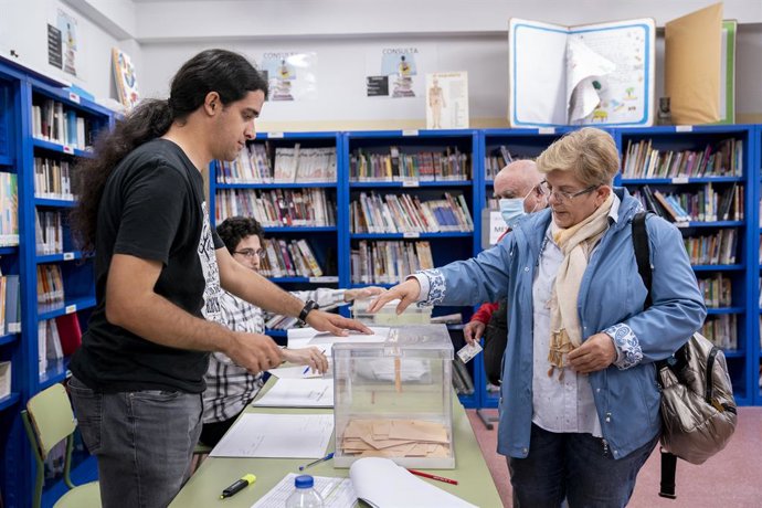 Una dona diposita el seu vot en una urna d'un collegi electoral, a 28 de maig del 2023, a Madrid