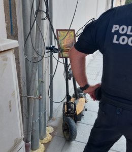 Un agent de la Policia Local d'Adra al costat del patinet amb una fotode Franco emprat per a l'atropellament