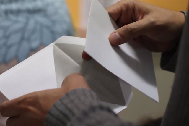 Un votante introduce su papeleta en el sobre.