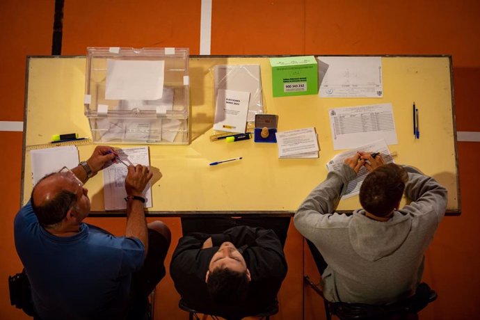 Los componentes de una mesa electoral esperan a que los ciudadanos voten en la Escola Grvol, a 28 de mayo de 2023, en Barcelona, Cataluña (España). Hoy, 28M, se celebran elecciones municipales en un total de 8.131 ayuntamientos y elecciones autonómicas