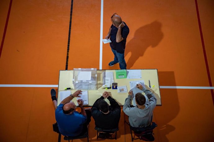 Un hombre espera a que los componentes de la mesa electoral compueben su identidad para votar en la Escola Grvol, a 28 de mayo de 2023, en Barcelona, Cataluña (España). 